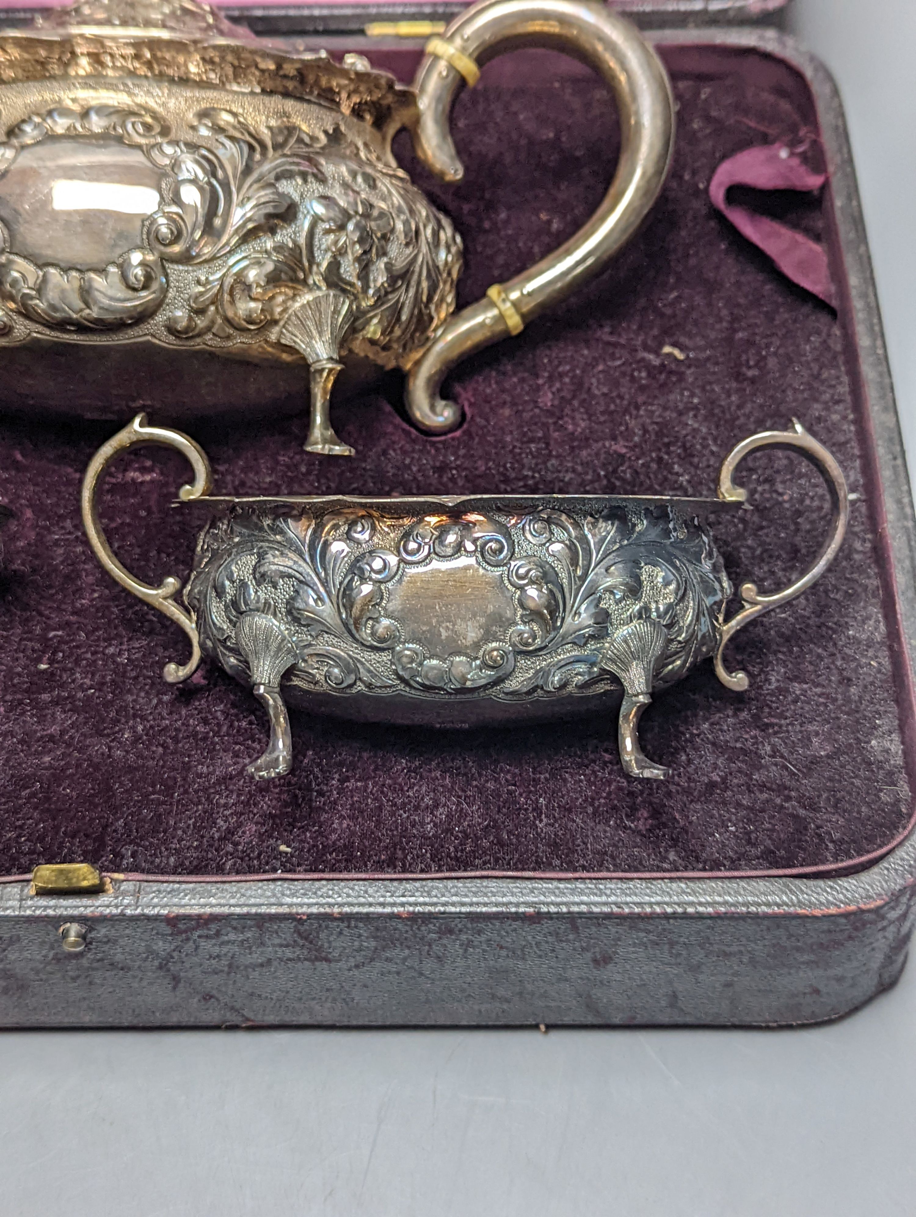A cased late Victorian Scottish repousse silver three piece tea set, Hamilton & Inches, Edinburgh, 1897, gross 21.5oz.